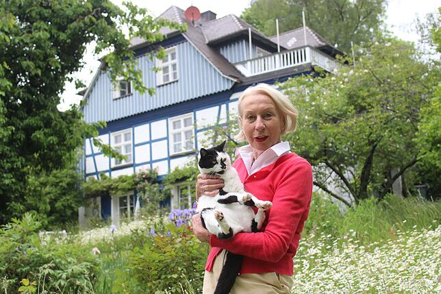 Kristin Müller-Hausser mit ihrer Katze im großen Naturgarten einer von ihr sanierten Villa, die sie von ihren Eltern übernommen hat. Sie ...
