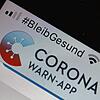 Die offizielle Corona-Warn-App ist auf einem Smartphone zu sehen, darüber steht der Hashtag &ldquo;#BleibGesund&bdquo;. Die App soll die ...