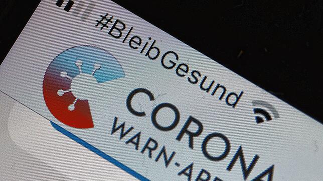 Die offizielle Corona-Warn-App ist auf einem Smartphone zu sehen, darüber steht der Hashtag &ldquo;#BleibGesund&bdquo;. Die App soll die ...