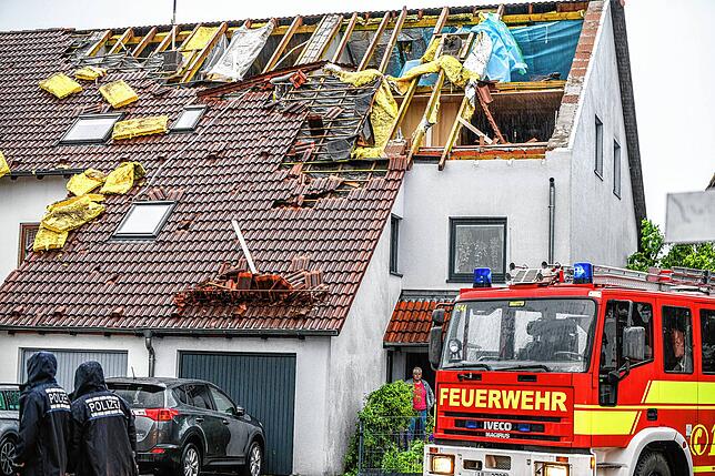 Einsatzkräfte von Feuerwehr und Polizei sind im Stadtteil Donaustetten im Einsatz, nachdem durch das Unwetter das Dach eines ...