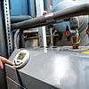 Ein Mann bedient eine Luftwärmepumpe, die im Keller eines Wohnhauses steht. Die Bundesregierung plant, dass ab 2024 jede neu eingebaute ...