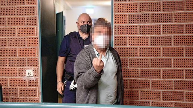 Einer der Angeklagten macht zu Beginn des dritten Verhandlungstages deutlich, was er davon hält, fotografiert zu werden.