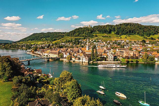 Luftaufnahme von Stein am Rhein. Auf dem Rhein fährt ein Passagierschiff.