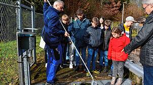 Klärwärter Erik Rogg (links) zeigt den Schülern im Beisein von Bürgermeister Thomas Kaiser anhand einer Probe, wie das Wasser nach der ...