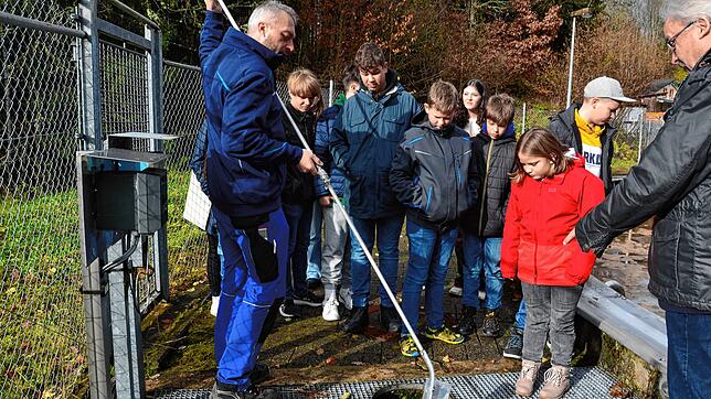 Klärwärter Erik Rogg (links) zeigt den Schülern im Beisein von Bürgermeister Thomas Kaiser anhand einer Probe, wie das Wasser nach der ...