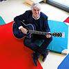 So kennt man ihn: Rolf Zuckowski mit Gitarre in einer Kita.