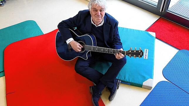 So kennt man ihn: Rolf Zuckowski mit Gitarre in einer Kita.