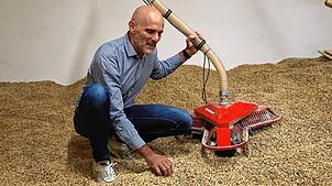 Helmut Schellinger erläutert in einem Lagerraum für Holzpellets die Funktionsweise des eigenen patentierten Fördersystem.