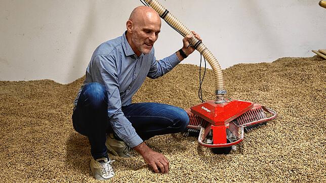 Helmut Schellinger erläutert in einem Lagerraum für Holzpellets die Funktionsweise des eigenen patentierten Fördersystem.