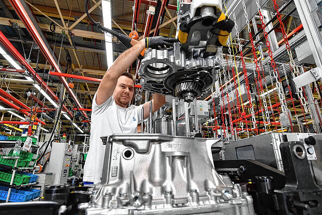 Ein Mitarbeiter montiert im ZF-Werk in Friedrichshafen ein TraXon-Getriebe für LKW. Da die Nutzfahrzeugproduktion gut läuft, steht im ...
