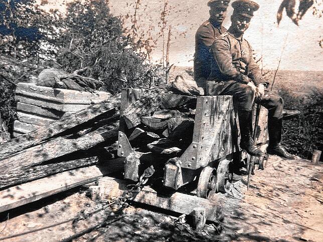 Deutsche Soldaten auf einer Lore. Solche Loren auf Schienen wurden auch beim Stollen- und Tunnelbau eingesetzt.