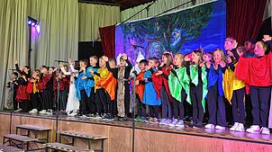 Alle 47 Schülerinnen und Schüler stehen auf der Bühne und führen gemeinsam die Oper „Die Zauberflöte“ von Wolfgang Amadeus Mozart auf. ...
