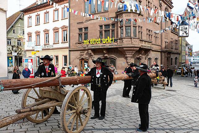 Die Zimmerleute bringen den langen Narrenbaum in die Innenstadt.