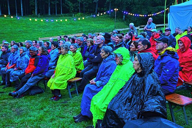 Ein kräftiger Regenschauer hält die Besucher nicht davon ab, sich das Theaterstück anzusehen.