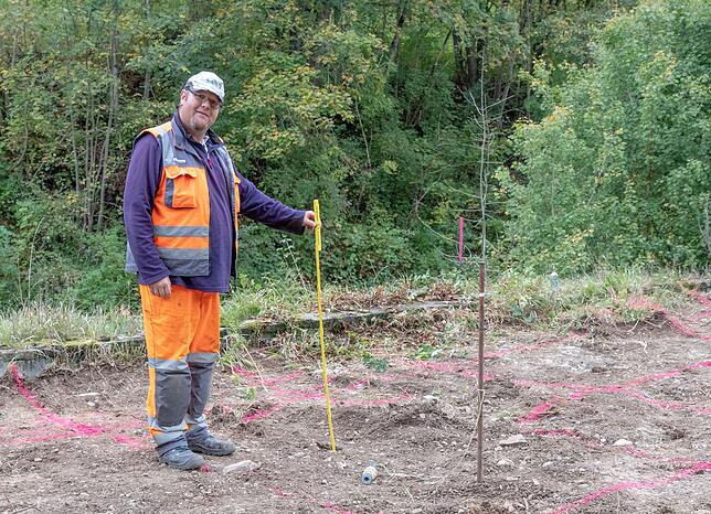 Ralf Finkbeiner erläutert Details zu der laufenden Vermessung vor Ort für die Fundamente der neuen Fußgängerbrücke.