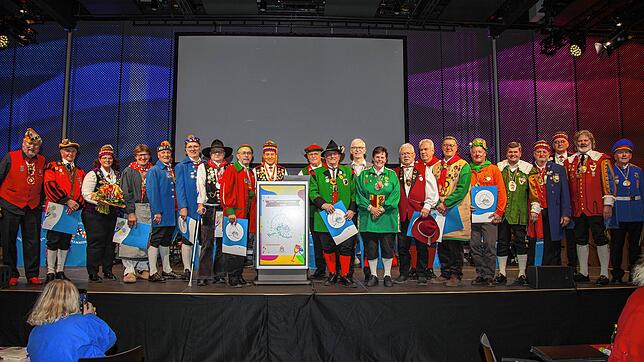 Alle Geehrten stehen mit dem Präsidenten der Narrenvereinigung Hegau-Bodensee, Rainer Hespeler (hinter dem Rednerpult), auf der großen ...