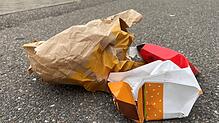 Wenige Monate vor der Einführung einer kommunalen Verpackungssteuer liegt Müll aus Fastfood-Verpackungen auf dem Gehweg der ...