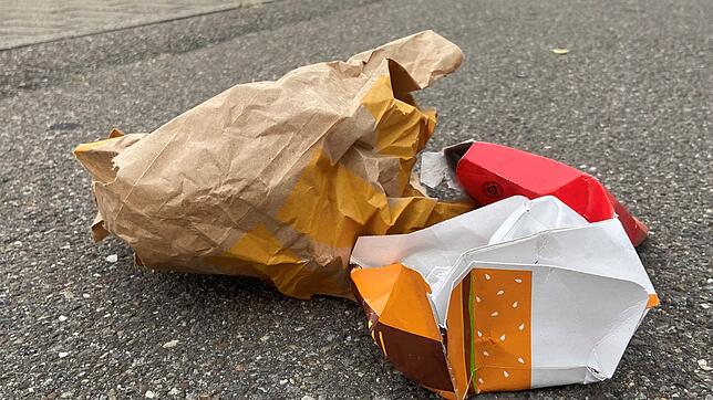 Wenige Monate vor der Einführung einer kommunalen Verpackungssteuer liegt Müll aus Fastfood-Verpackungen auf dem Gehweg der ...