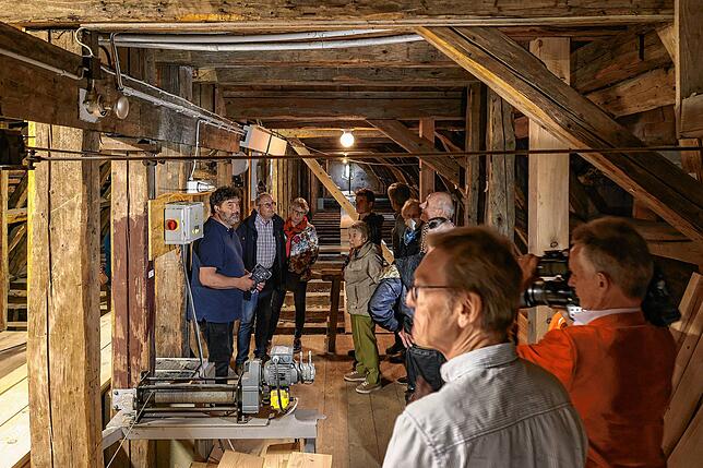 Architekt Bruno Siegelin (links) erklärt den Besuchern die Arbeiten im Dachstuhl des Kirchenschiffs.