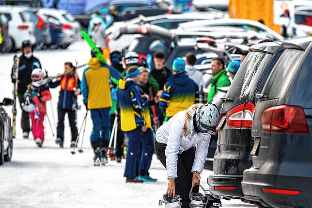 Skifahrer stehen auf einem Parkplatz im österreichischen Skigebiet Hinterstoder-Höss. Auch in Österreich ist in der Saison 2022/23 mit ...