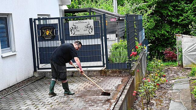 Ein Mann säubert in Degerfelden nach dem Gewitter den Hof. Bild: Heinz Vollmar
