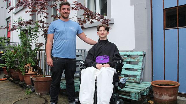 Jannis Pagels mit Tino Freudenberg, einem seiner Assistenten, die ihn rund um die Uhr betreuen und pflegen. Zwischen den beiden ist ein ...