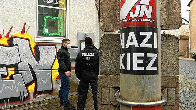 Polizisten stehen vor der Gaststätte „Bull‘s Eye“. An einem Pfahl ist ein Aufkleber mit der Aufschrift „Nazi ...