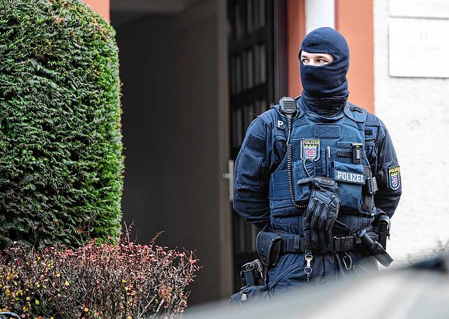 Bei der Razzia gegen sogenannte „Reichsbürger“ sichert ein Polizist ein durchsuchtes Objekt in Frankfurt.