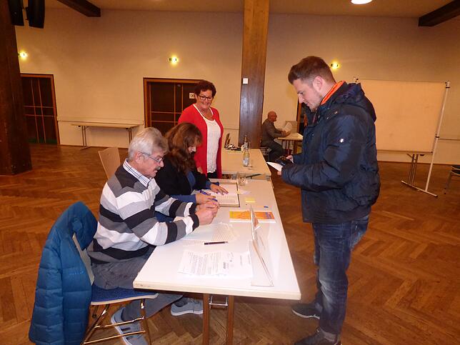 Ein Markdorfer Bürger gibt am Tisch von Karl Häuptle, Barbara Härle und Renate Baumgärnter in der Stadthalle seine Stimme ab.