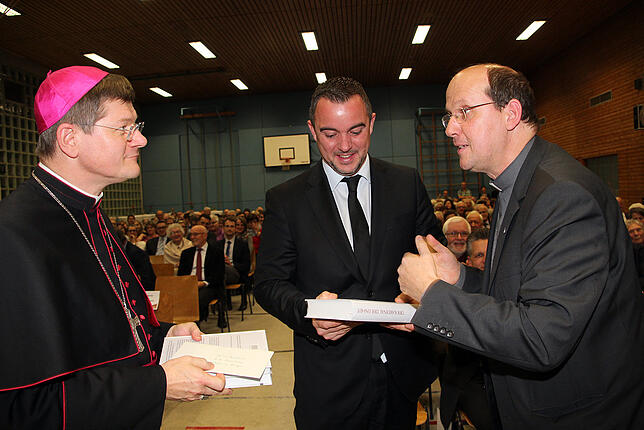 Jesuiten-Provinzial Johannes Siebner (rechts) überreicht Erzbischof Stephan Burger und Bürgermeister Markus Keller je ein Exemplar des ...