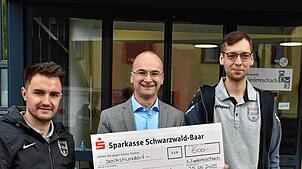 Adrian Petrolli (links) und Mathias Bantle (rechts) überreichten nun im Namen der FC Fischbach einen Spendenscheck an Bürgermeister ...