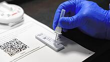 Ein Mitarbeiter des Testzentrums im Konstanzer Club Berry&lsquo;s tröpfelt die Testlösung mit dem Nasensekret eines Getesteten auf ein ...