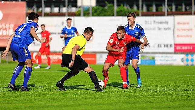 Ivo Colic vom 1. FC Rielasingen-Arlen im Zweikampf mit zwei Gegenspielern und dem Schiedsrichter.