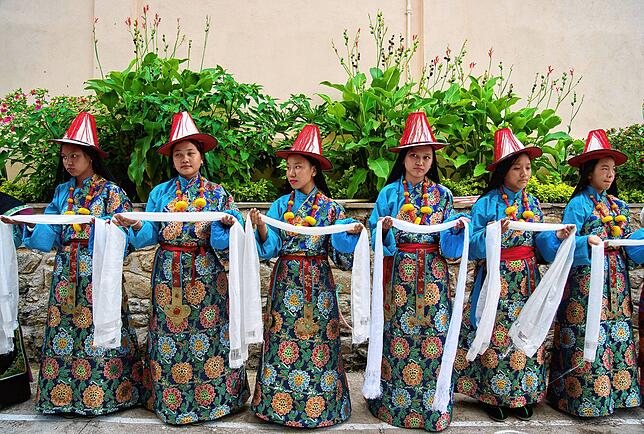 Exil-Tibeterinnen in traditioneller Kleidung tragen ein zeremonielles Tuch als Teil der Rituale während der Feierlichkeiten zum 90. ...