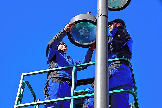 Christoph Beringhoff (rechts) und Peter Zadoni von der EGT montieren die modernen LED-Leuchten, die den neuen Marktplatz künftig ...