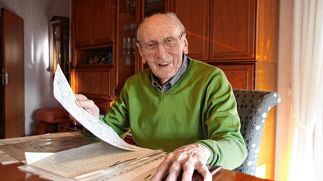 Franz Ziwey blättert beim Gespräch mit dem SÜDKURIER in seinem Wohnzimmer durch gesammelte Erinnerungsstücke.