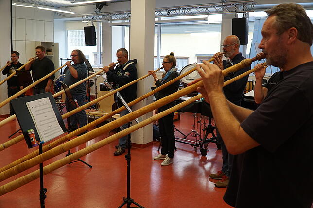 Zehn Männer und eine Frau sind angetreten das musizieren mit dem Alphorn zu erlernen.