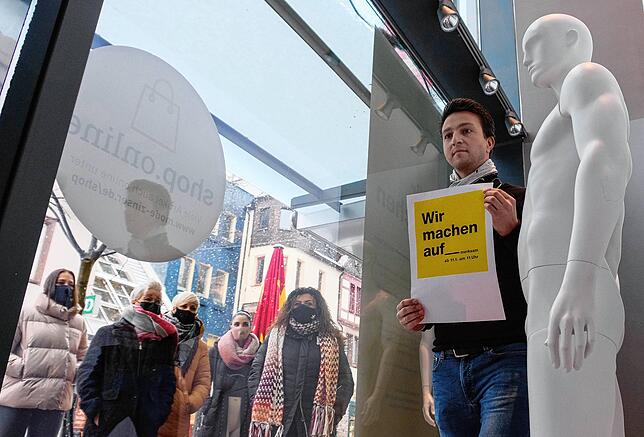 Der Geschäftsführer von Mode Zinser in Singen, Stefan Suzsek, steht im Schaufenster neben einer nackten Puppe. Mit dem Plakat will der ...
