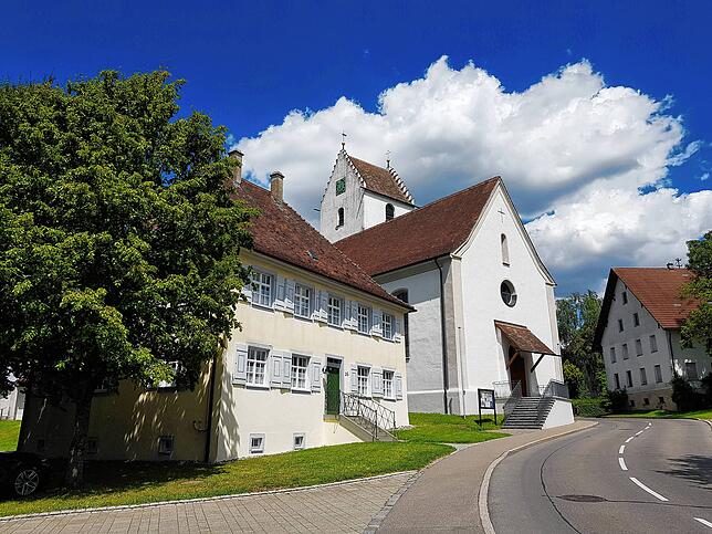 Die Durchgangsstraße durch Liggersdorf. Am linken Straßenrand sind die Kirche St. Cosmas und Damian und das Kaplaneihaus zu sehen.