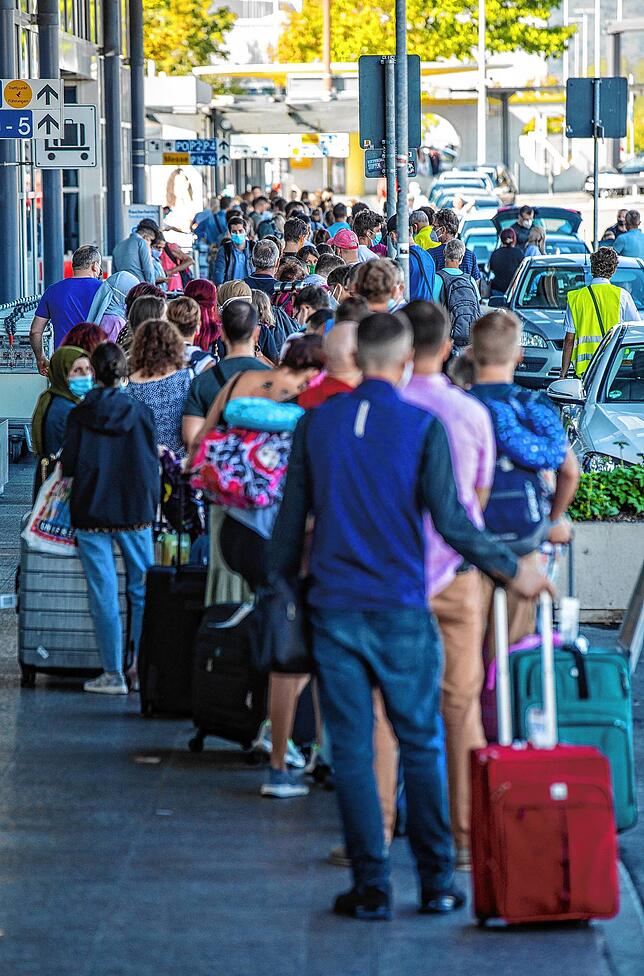 Reiserückkehrer, vorwiegend aus Spanien, stehen vor dem Corona-Testzentrum am Flughafen Stuttgart. Angesichts erhöhter ...