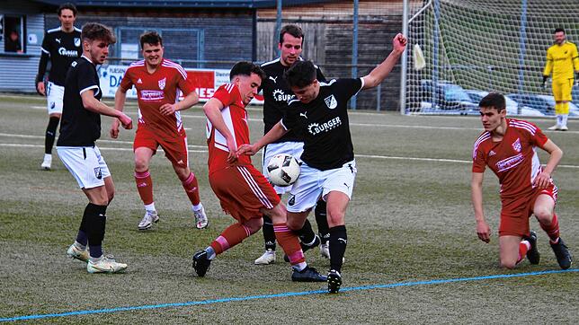Der Hinterzartener Manuel Birkle (rotes Trikot, mitte) kämpft mit dem Schonacher Mauro Guaglianone um den Ball.