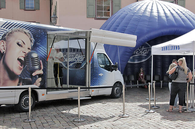 Vom Anmeldestand geht es für die Kandidaten ins blaue Wartezelt, danach wird im Transporter vor einer zweiköpfigen Jury gesungen.