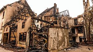 16.06.2025, Baden-Württemberg, Villingen-Schwenningen: Schutt liegt zwischen den Mauerresten eines ausgebrannten Hauses. Am Vorabend ist ...