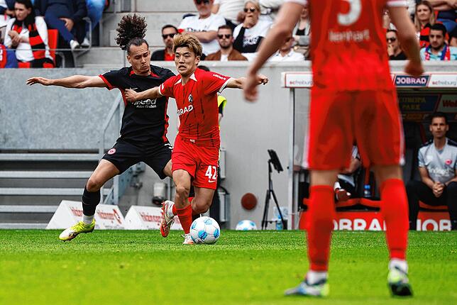 Frankfurts Arthur Theate (l) im Duell mit Freiburgs Ritsu Doan.