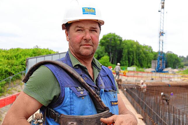Und zwar von Bernd Holdenried. Er ist Polier für die Baufirma Steidle, die auf dieser Baustelle unter anderem mit Hochbauarbeiten ...