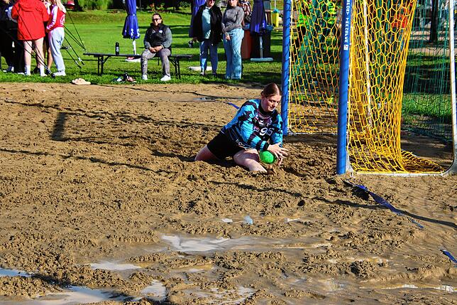 Die Beine einer Torhüterin sind im schweren Sand eingegraben.