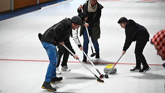 Philipp Weisser, Heike Fichter, Anja Moosmann und Nico Fichter, von links, wischen den Curlingstein möglichst in den Zielkreis. Bilder: ...