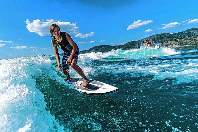 Bei der Wakeboardschule Crazywake kann man beim Wakesurfen in den Wellen eines Bootes surfen.