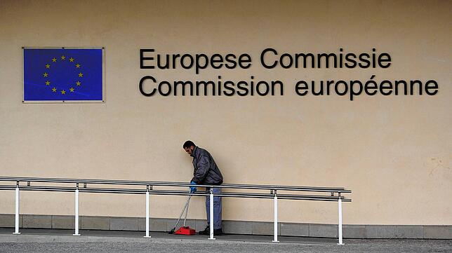 Ein Mann kehrt vor der EU-Kommission Müll auf. Er zählt sicher nicht zu den gut bezahlten Beamten.