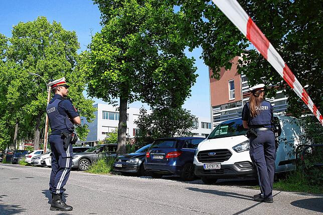 Polizeibeamte stehen in der Nähe des Tatorts.